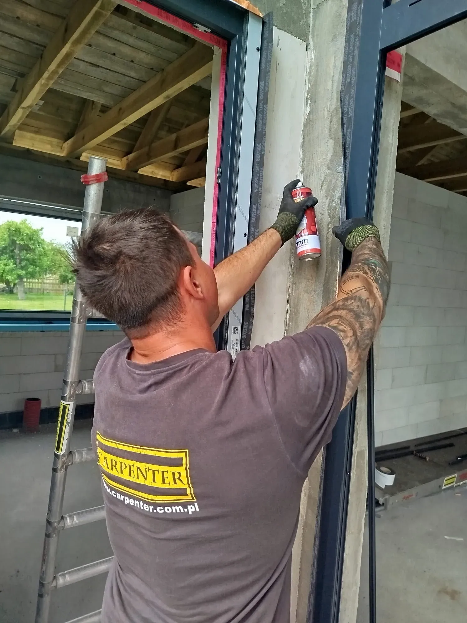 Przyklejanie zewnętrznej taśmy podczas szczelnego montażu okna w Bydgoszczy