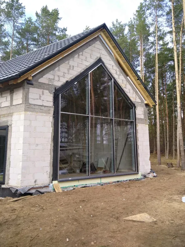 Wysokie przeszklenie dopasowane do kształtu szczytu domu